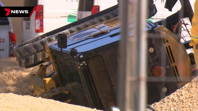 A worker has been rushed to hospital after becoming trapped under an excavator that rolled at a One Tree Hill construction site. Picture: 7NEWS