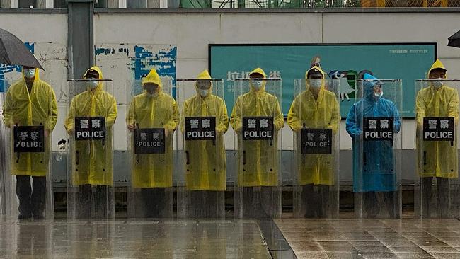 Police keep watch outside the Evergrande headquarters. (Photo by Noel Celis / AFP)