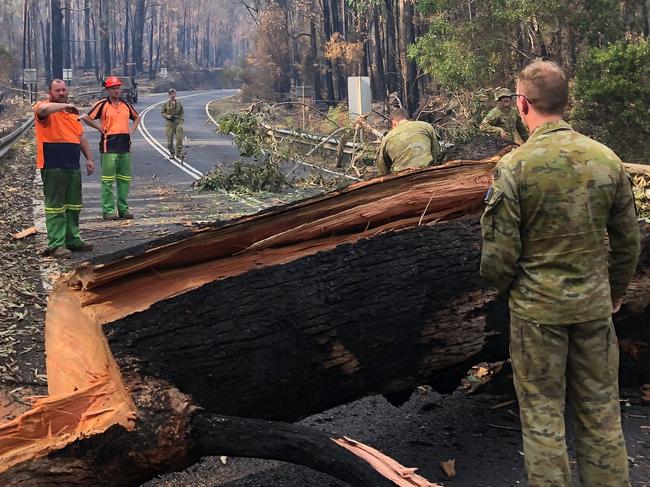 10/01/20Australian Army 7 Royal Australian Regiment, clearing a felled tree with civilian authorities on Orbost-Mallacoota after delivering supplies to Mallacoota CFA. *** Local Caption *** The Australian Defence Force (ADF) has commenced Operation Bushfire Assist 19-20 and has stood up a Joint Task Force in New South Wales and Victoria to enhance Defence support following devastating bushfires in the South East of Australia.  ADF members are working side by side with emergency services personnel in the State Disaster Coordination Centre (SDCC) of the New South Wales Rural Fire Service Headquarters and alongside the Victorian CFA is the Country Fire Authority and Metropolitan Fire Brigades to provide best effect of ADF assets.  HMAS Choules and MV Sycamore have sailed from Sydney and will operate off the Southern NSW/North East Victorian coast to provide support to communities cut off due to the bushfires.  Defence is also providing transport and other capabilities such as aviation ground support, logistics, engineering and accommodation support the firefighting effort.