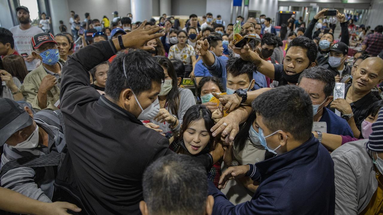 Airport security staff attempt to control the crowd as Filipinos hoping to get on flights out of Manila hours before it is placed on lockdown queue at Ninoy Aquino International Airport on March 14, 2020 in Manila, Philippines. Picture: Ezra Acayan/Getty Images