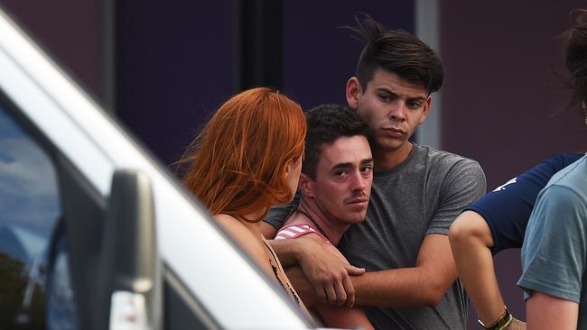 Backpackers comfort each other outside the Home Hill Backpackers after three people were stabbed. Picture: Zak Simmonds