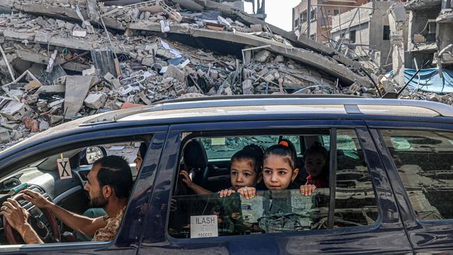 A Palestinian family drives through the rubble of Gaza City on Friday (AEDT) ahead of an expected ground invasion by Israeli defence forces. Picture: AFP