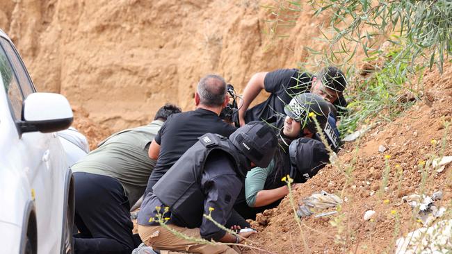 Journalists take cover during a rocket attack alert in southern Israel. Picture: AFP