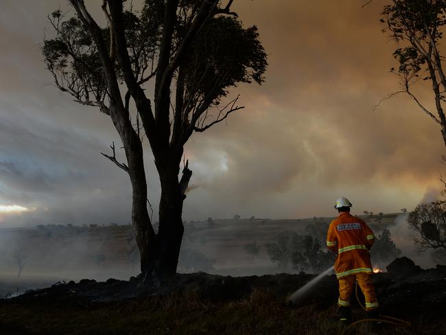 A firefighter battles a grass fire on the Golden Highway between the rural towns of Merriwa and Cassilis in the NSW Central West. Picture: Jeremy Piper