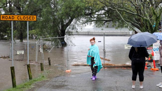 People out looking at the rising flood water of the Hawkesbury River near the New Windsor Bridge in Windsor. Picture: Damian Shaw