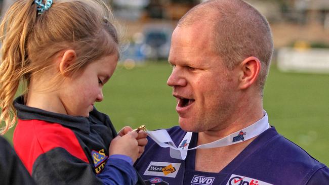 Diggers Rest coach Jamie Lobb enjoys the spoils with his daughter. Picture: Aaron Cook