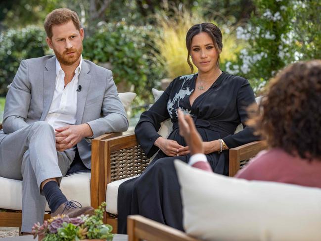 This undated image released March 7, 2021 courtesy of Harpo Productions shows Britain's Prince Harry (L) and his wife Meghan (C), Duchess of Sussex, in a conversation with US television host Oprah Winfrey. - Britain's royal family on March 7, 2021 braced for further revelations from Prince Harry and his American wife, Meghan, as a week of transatlantic claim and counter-claim reaches a climax with the broadcast of their interview with Oprah Winfrey. The two-hour interview with the US TV queen is the biggest royal tell-all since Harry's mother princess Diana detailed her crumbling marriage to his father Prince Charles in 1995. (Photo by Joe PUGLIESE / HARPO PRODUCTIONS / AFP) / RESTRICTED TO EDITORIAL USE - MANDATORY CREDIT "AFP PHOTO/ HARPO PRODUCTIONS -  Joe PUGLIESE" - NO MARKETING NO ADVERTISING CAMPAIGNS - DISTRIBUTED AS A SERVICE TO CLIENTS --- NO ARCHIVE ---