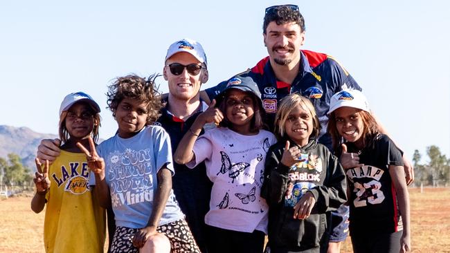 Adelaide’s Izak Rankine and Reilly O’Brien with APY Lands kids. Picture: AFC