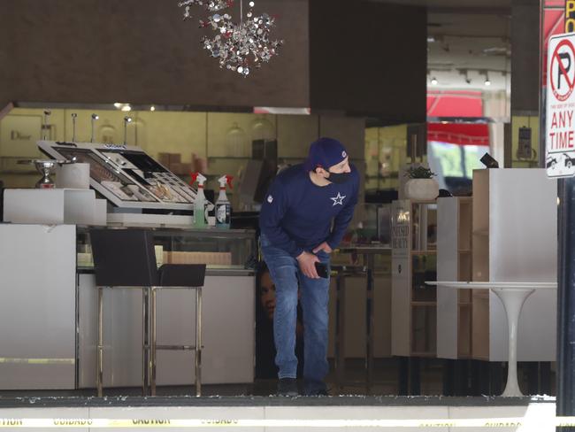 A man peers out of a broken window display in downtown Dallas after a night of protests over the death of George Floyd. Picture: AP Photo/LM Otero