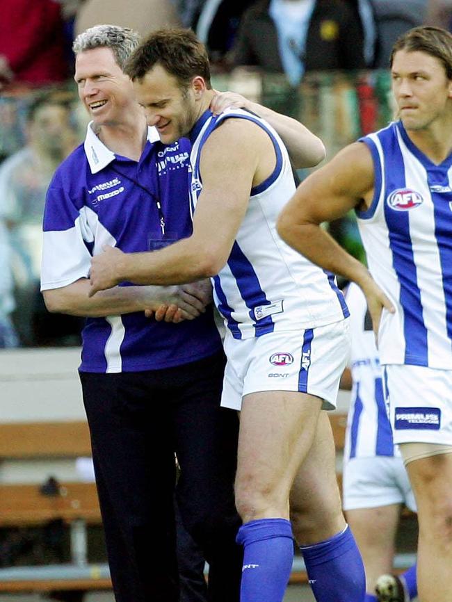 Football manager Tim Harrington congratulates Rocca at quarter-time on the birth of his son.