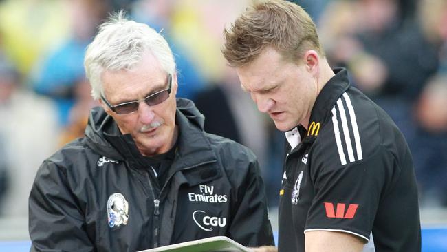 Mick Malthouse and understudy move the magnets during the 2011 Grand Final against Geelong. Buckley took the coaching reins from Malthouse the following year.