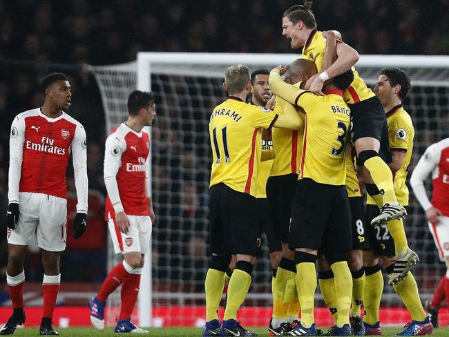 Watford's French midfielder Younes Kaboul is mobbed by teammates.