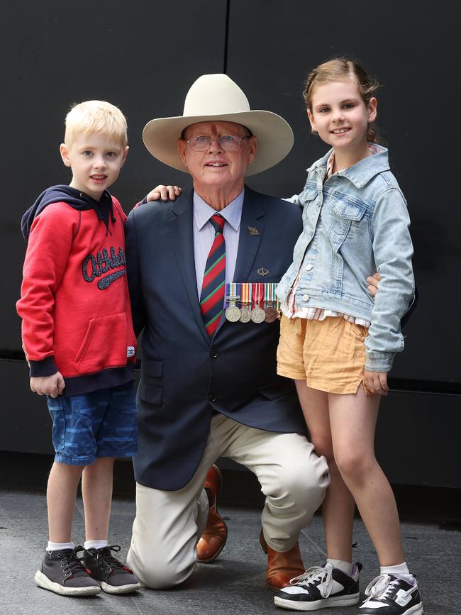 Barry Broderick, 76, of Ferny Hills, with his grandchildren Thomas Borcheres and Estelle Borcheres at the ANZAC Day march, Brisbane. Picture: Liam Kidston