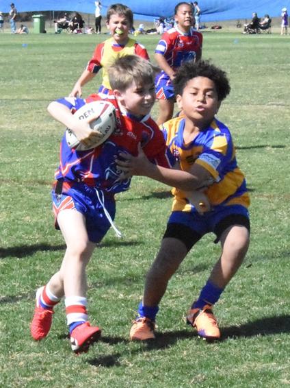 The Redbank Plains under-9 footballer tries to shake off the determined Norths tackler. Picture: Gary Reid