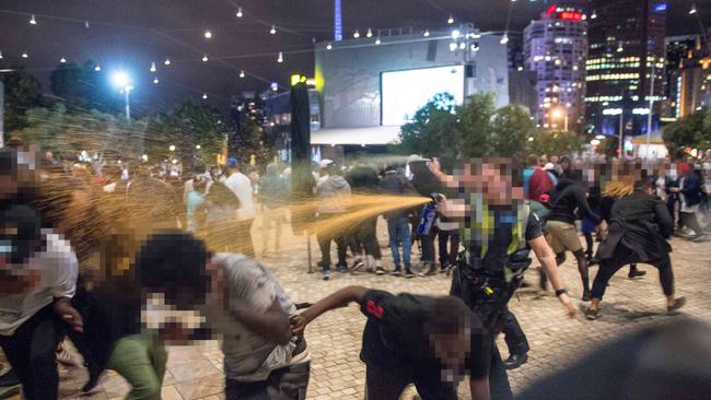 Police use pepper spray to attempt to break up a massive gang brawl at Melbourne’s Federation Square during Moomba festivities in March. Pic: (Jake Nowakowski/News Corp Australia)