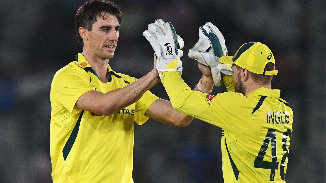 Australian captain Pat Cummins celebrates with teammate Josh Inglis.  Photo by ARUN SANKAR / AFP