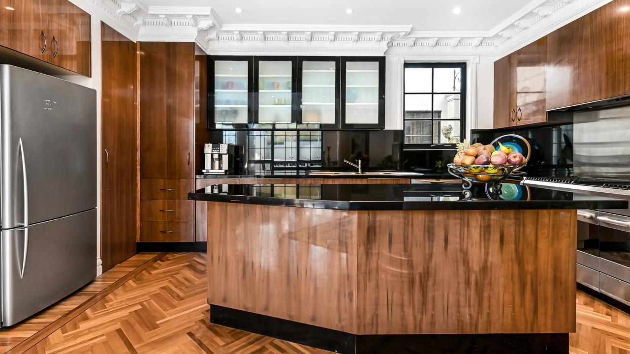 The spacious kitchen has gloss timber cabinetry, 40mm jet black stone counter tops and matching splashback, a walk-in pantry and 1200mm freestanding oven, warmer and gas cooktop.