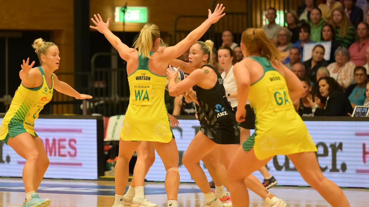 Whitney Souness of the Silver Ferns (R) is surrounded by Diamonds.