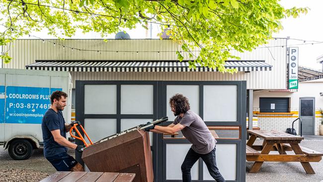 Workers at Melbourne’s Notting Hill Pub move an outdoor foosball table as they prepare for closure. Picture: Asanka Ratnayake/Getty Images