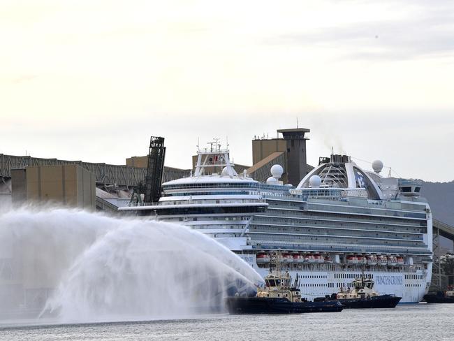 A tug boat gives a water salute as cruise liner Ruby Princess prepares to leave Port Kembla. Picture: Saeed Khan/AFP