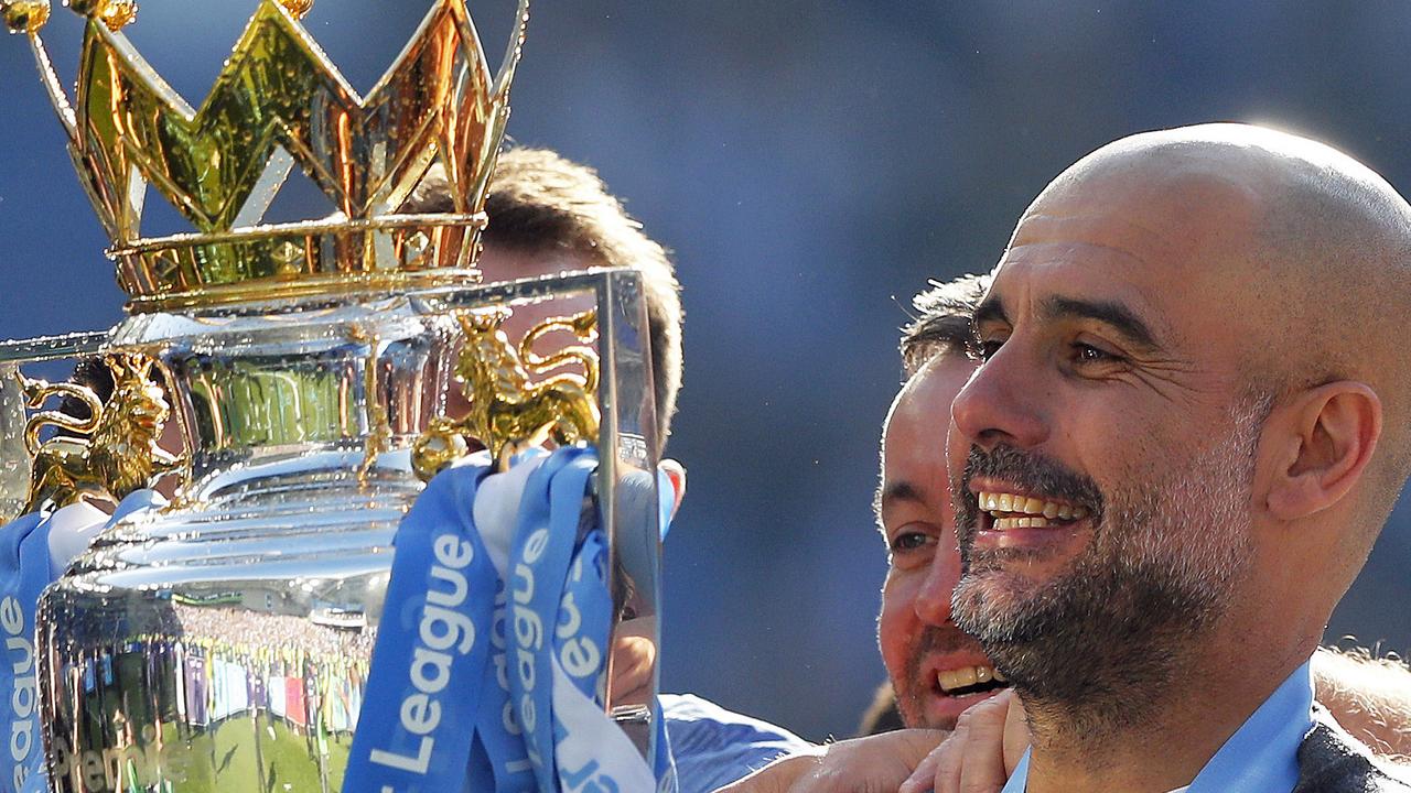 Manchester City coach Pep Guardiola lifts the English Premier League trophy.