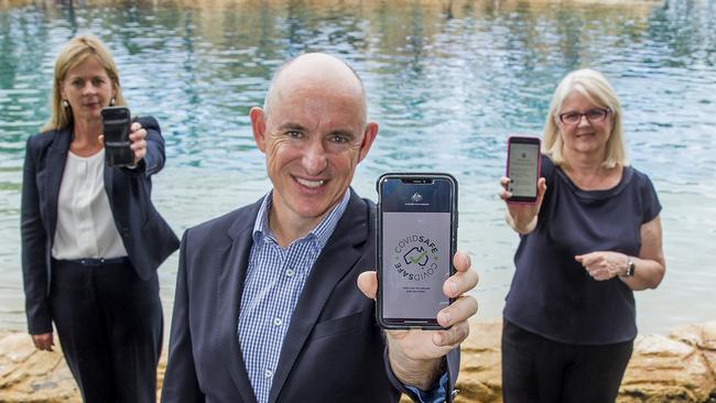 Government Services Minister Stuart Robert holds up a phone displaying the COVIDSafe app flanked by federal MPs Angie Bell and Karen Andrews. Picture: Jerad Williams