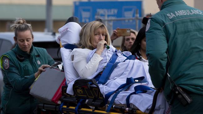 A woman is taken from the centre by ambulance after being hurt in the commotion. Picture: Brett Hartwig