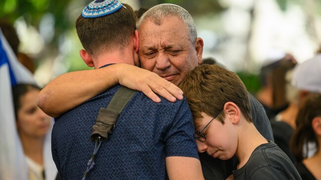 Gadi Eisenkot, centre, embraces family members at the funeral of his son, Master Sergeant Gal Eisenkot, who died in a Hamas explosion in Gaza. Picture: Getty Images