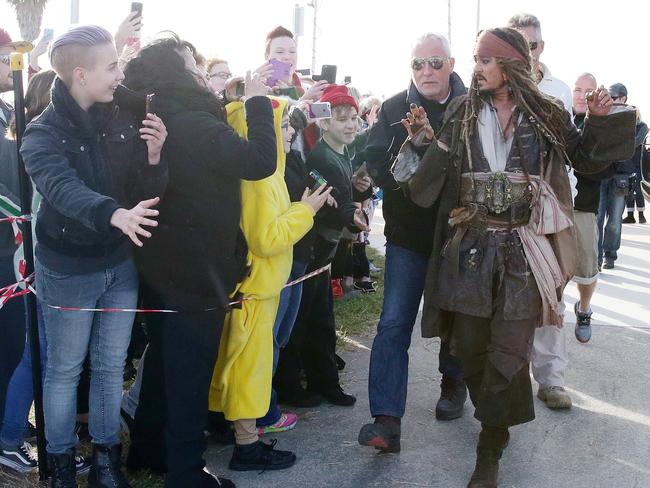 Johnny Depp surrounded by security leaves on a boat to be ferried out to Moreton Bay to continue filming Pirates of the Caribbean. Photographer: Liam Kidston