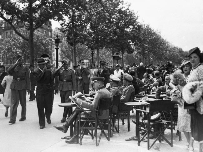 Occupying German troops salute officers at a Parisian cafe in 1940. Picture: Supplied