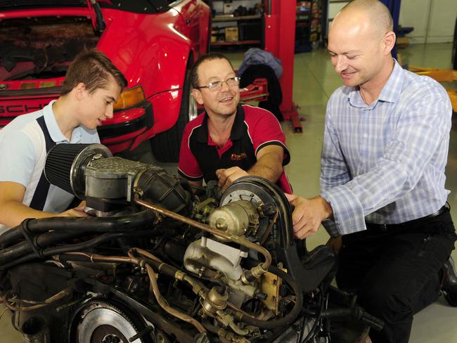 Work experience participant with Autowerks owner Simon Greenwood and CASAR Park co-founder Brad Wilson looking over an engine.