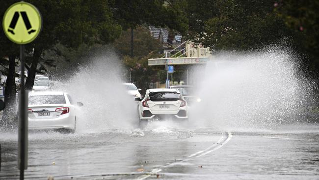 Cars drive through a flooded Illawarra Rd atMarrickville. Picture: Adam Yip