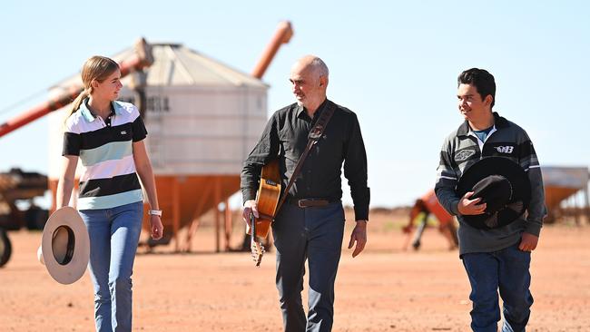 Singer-songwriter Paul Kelly with Dirranbandi State School students Julia Killen and Billy Turnbull on Sunday, on a property north of Dirranbandi, about 600km south west of Brisbane. Picture: Lyndon Mechielsen