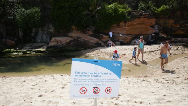 Children continue to play in the polluted waterway despite signs warning of the health risk. Picture: Craig Wilson