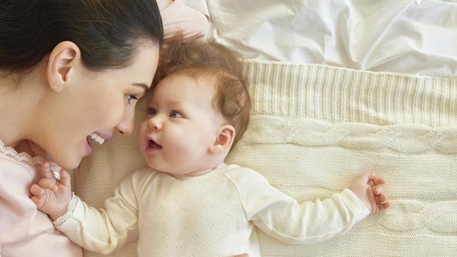 happy family. mother playing with her baby in the bedroom.