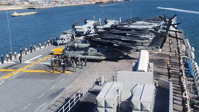 US sailors and Marines “man the rails” in front of and behind some of the aircraft on board the USS America as it cruised into Brisbane on Tuesday. Picture: Jodie Munro O'Brien