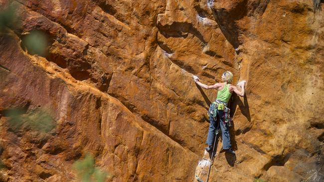 A rock climber clings to a cliff face in the Grampians, a world-renowned climbing site in Victoria that is subject to strict heritage laws. Picture: Simon Carter