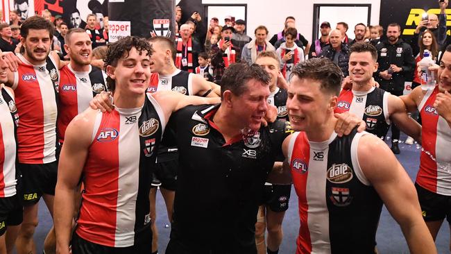 Nick Coffield, interim St Kilda coach Brett Ratten and debutant Doulton Langlands are showered during the club song after their win over Western Bulldogs. Picture: AAP Image/Julian Smith.