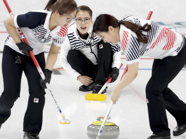 South Korea's Kim Seonyeong, left, and Kim Yeongmi, right, sweep the ice as teammate skip Kim Eunjung, center, looks on during a women's curling match against United States at the 2018 Winter Olympics in Gangneung, South Korea, Tuesday, Feb. 20, 2018. (AP Photo/Natacha Pisarenko)