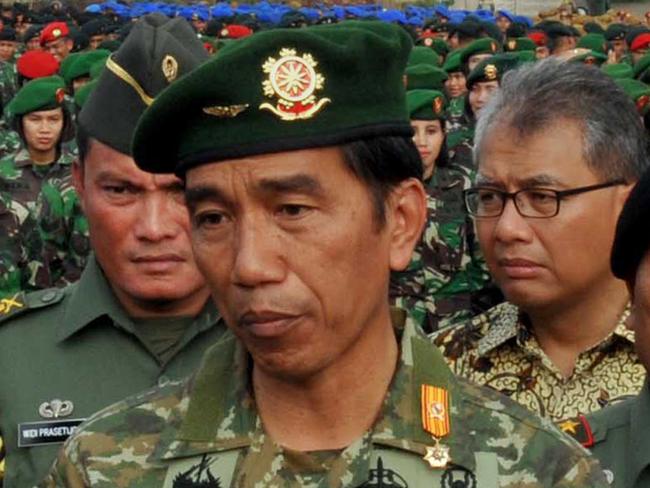 In this handout photograph taken and released by the presidential palace on May 13, 2015, Indonesian President Joko Widodo (C), in full military uniform, stands with Army Chief General Gatot Nurmantyo (L) and Armed Forces Chief General Moeldoko (R) before a formation of female army troops to lead the ceremony of the construction of a military hospital in Jakarta. AFP PHOTO / RIFKI / PRESIDENTIAL PALACE ----- EDITORS NOTE ---- RESTRICTED TO EDITORIAL USE MANDATORY CREDIT 