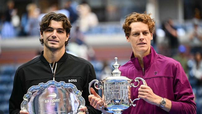 Jannik Sinner (R) and Taylor Fritz hold their trophies. Photo by ANGELA WEISS / AFP.