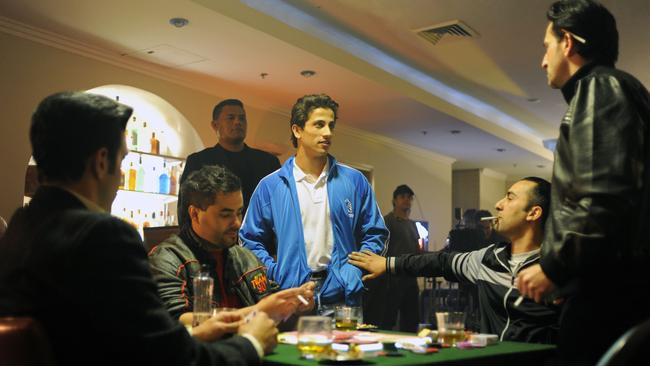 Michael Gittany (seated, second from left) appears in a scene from Underbelly: Golden Mile along with Australian actor Firass Dirani (centre). Picture: Supplied