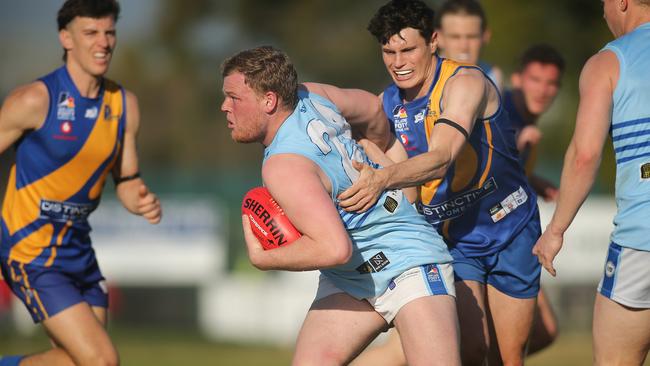 Sacred Heart Old Collegians’ Christian Vince shrugs a tackle from PHOS Camden’s Harry Young. Picture Dean Martin