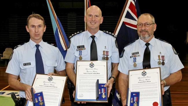 HERO COPS: Senior Constable Dave Murray, Sergeant Barry Haran and Senior Sergeant Nathan Blaine accept bravery awards after a heroic rescue of an elderly couple from a fire in Airlie Beach in 2015.