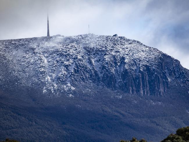 Hobartâs Kunanyi, Mt Wellington appeared briefly this morning to show a fresh coating of snow. Picture Eddie Safarik