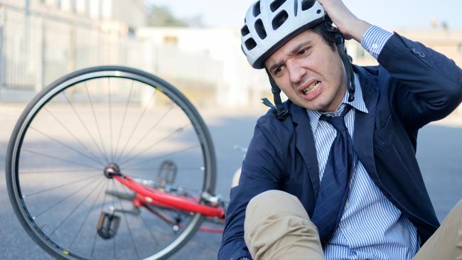 Aching man after bicycle accident on the asphalt, cycling, crash, generic