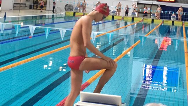 Tom Neill getting onto the blocks while swimming for Terrace last year.