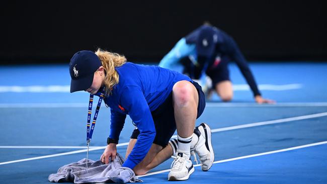 Ball kids work to mop up water on Kia Arena.