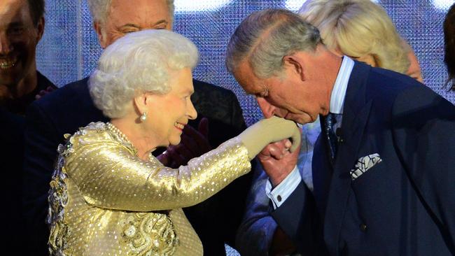 (FILES) In this file photo taken on June 04, 2012 Prince Charles kisses the hand of Britain's Queen Elizabeth II on stage as well as British singer Paul McCartney (R) looks on after the Jubilee concert at Buckingham Palace in London, on June 4, 2012. - Britain's Prince Charles said on November 8, 2018 he was not "stupid" enough to keep speaking out on contentious public issues once he becomes king in a rare interview about his future role. The eldest son of Queen Elizabeth II -- formally known as the Prince of Wales -- has long been seen as interfering because of his private lobbying of ministers and public statements on a range of subjects from architecture to the environment. (Photo by LEON NEAL / AFP)