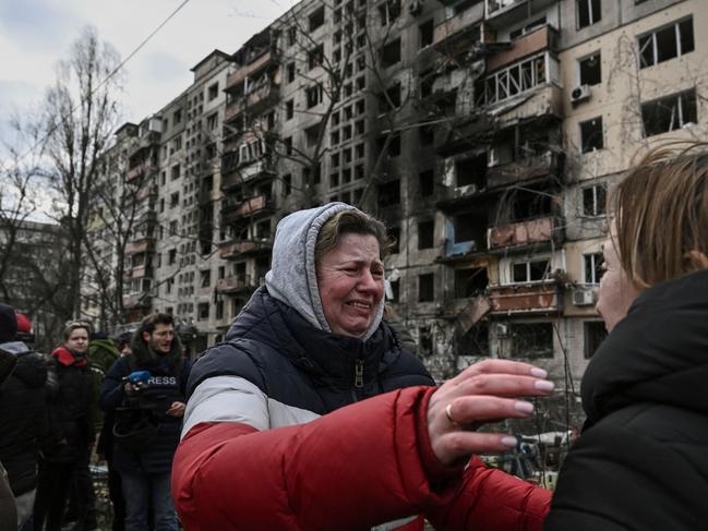 A woman reacts as she stands outside destroyed apartment blocks following shelling in the northwestern Obolon district of Kyiv. Picture: AFP.